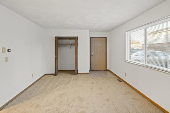 an empty room with a large window and a door