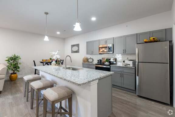 A modern kitchen with a white countertop and stainless steel appliances.