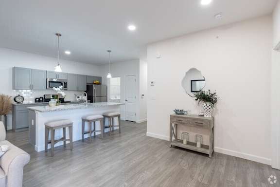 A kitchen with a white countertop and grey cabinets.