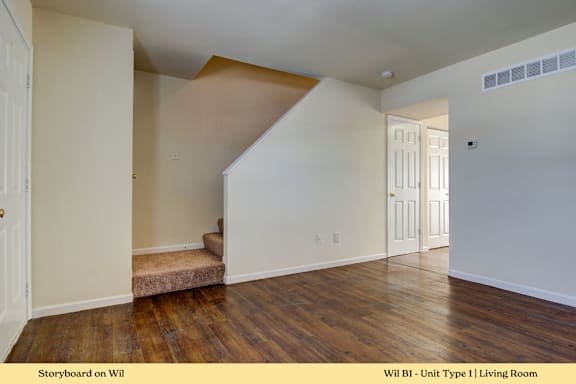 A living room with wooden floors and white walls.