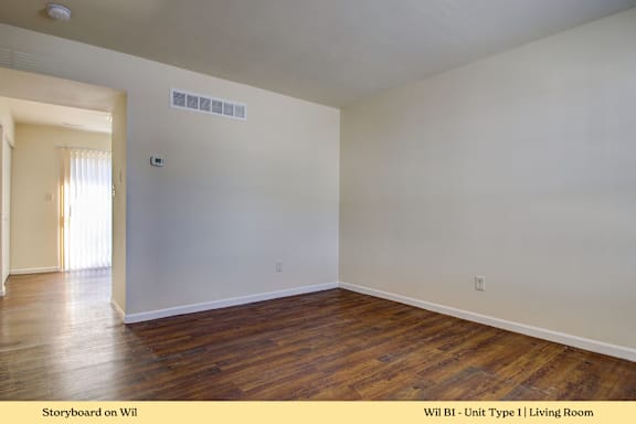 A living room with wooden floors and white walls.