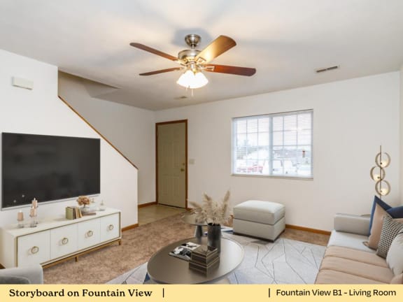 a living room with a ceiling fan and a tv