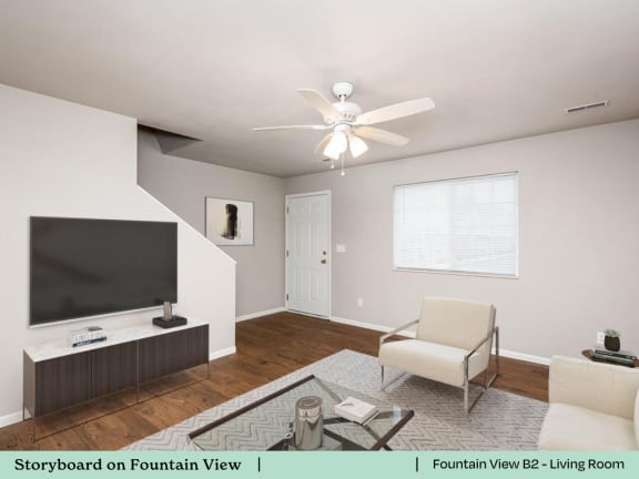 a living room with a ceiling fan and a tv