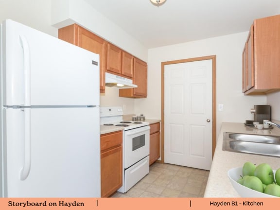 a kitchen with white appliances and wooden cabinets