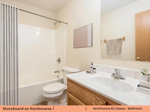 A white toilet sits next to a white sink in a bathroom.