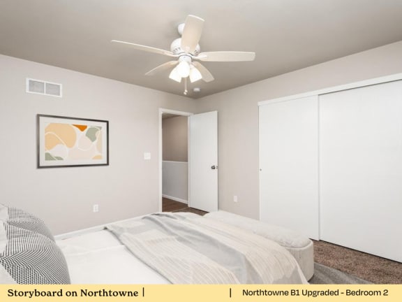 a bedroom with a bed and a ceiling fan