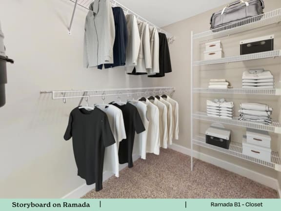 a walk in closet with a rack of clothes on the wall