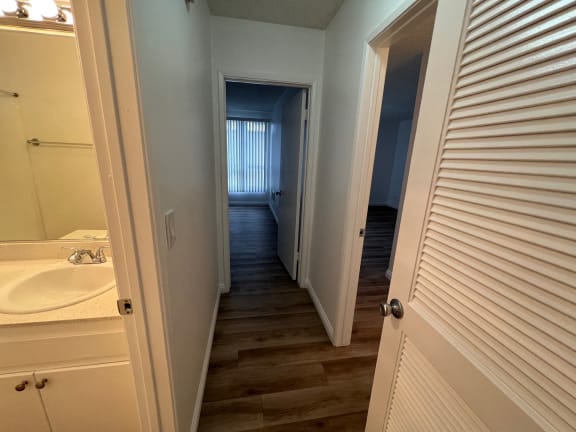 a view from the bathroom into the hallway with the door open