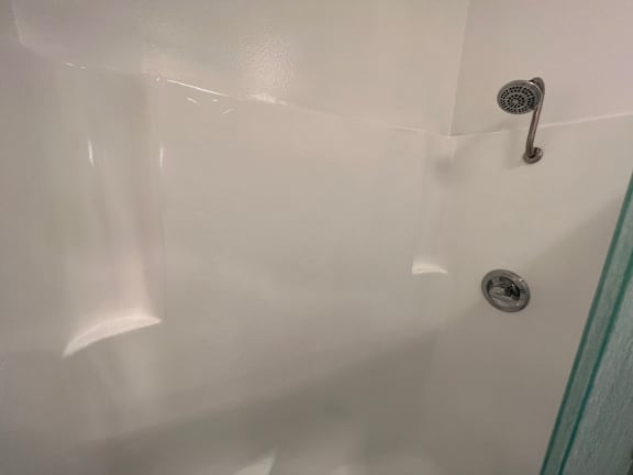 an empty shower in a bathroom with a shower curtain