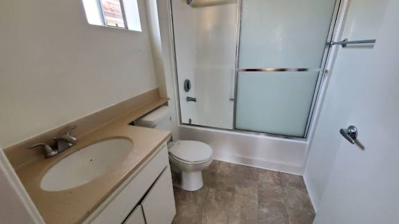 A bathroom with a toilet, sink, and shower.