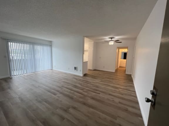 an empty living room with wood flooring and a large window