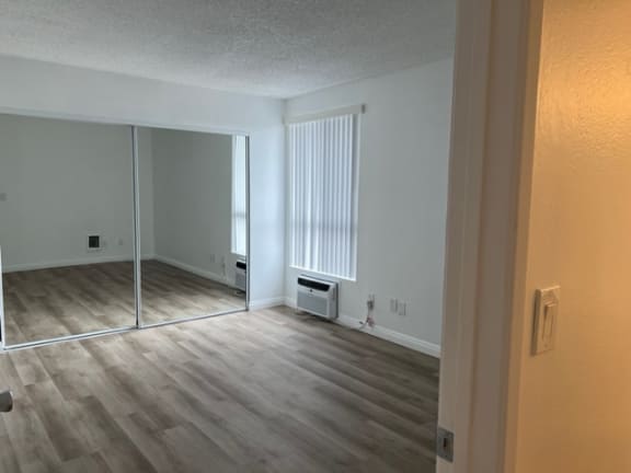 an empty living room with wood floors and a sliding glass door