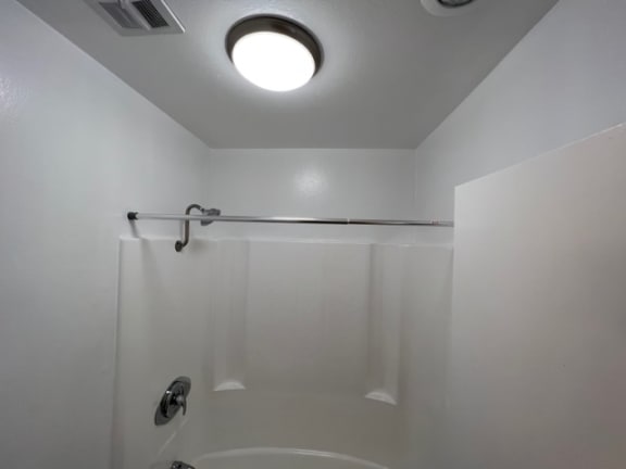 a bathroom with a shower and a light on the ceiling