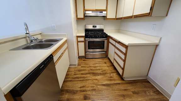 A kitchen with wooden floors and white walls.