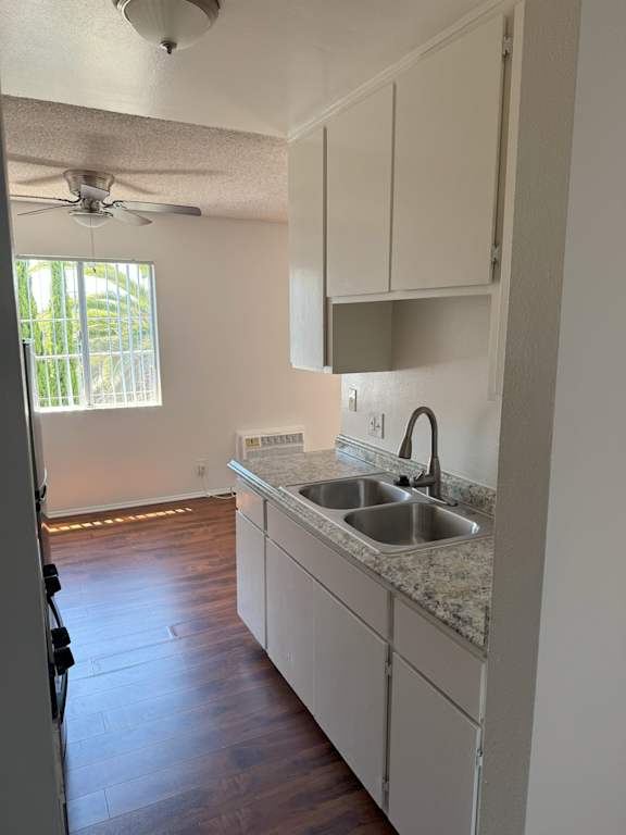 A kitchen with a sink and a refrigerator.