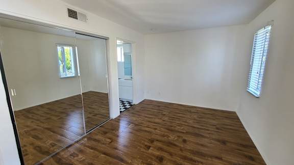 A room with wooden floors and a sliding glass door.