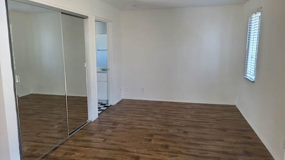 A room with a wooden floor and a sliding glass door.