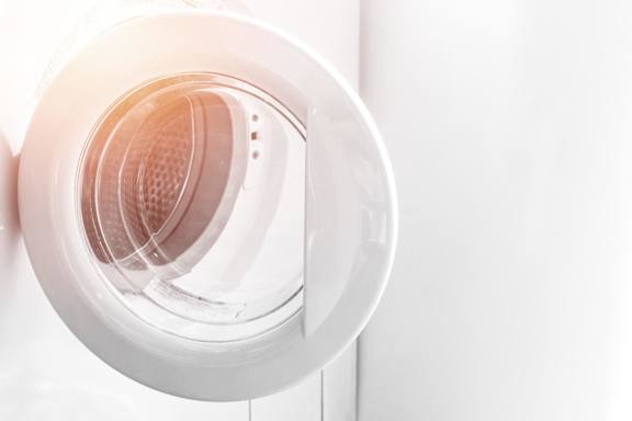 A white circular object with a pattern inside is mounted on a white wall.