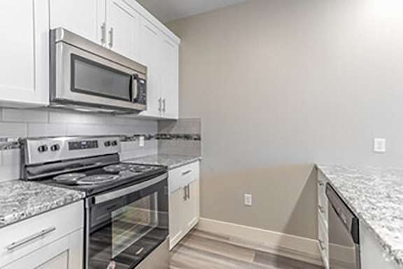 A kitchen with a stove top oven and microwave above it.
