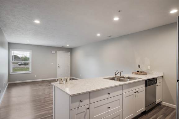A kitchen with white cabinets and a sink.