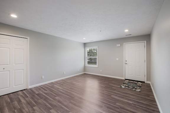 A room with wooden flooring and white walls.