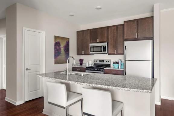 Modern kitchen with granite island and bar seating at Colony at Centerpointe Apartments, Virginia, 23114