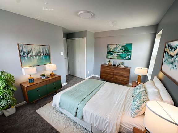 Floor Plan  A bedroom with a bed, nightstands, and a painting on the wall.at The Summit, Syracuse, 13210