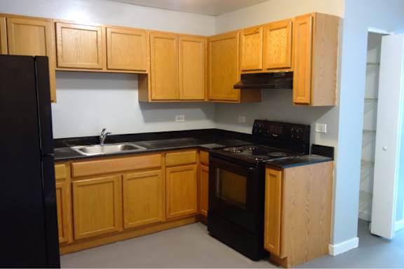 A kitchen with wooden cabinets and black appliances.