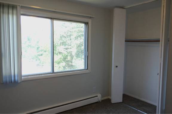 A room with a window and a heater.