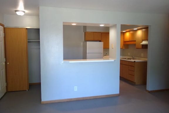 A kitchen with a white fridge and wooden cabinets.