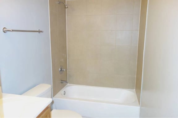 A white bathroom with a toilet, sink, and bathtub.
