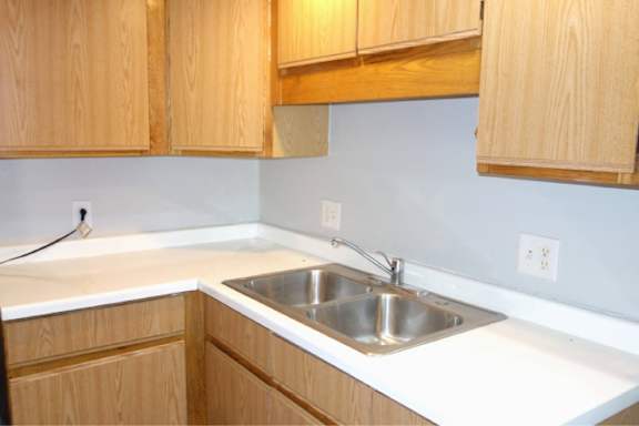 A kitchen with wooden cabinets and a white countertop.