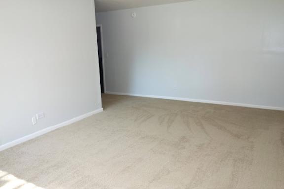 A room with a carpeted floor and white walls.