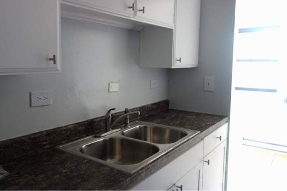 A kitchen with a sink and a counter.