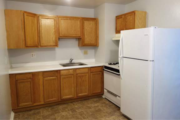 A kitchen with wooden cabinets and a white refrigerator.