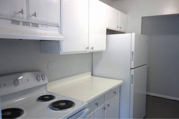 A white stove and oven in a kitchen with white cabinets.