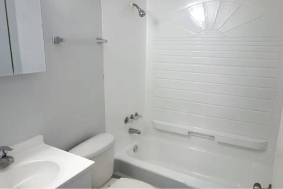 A white bathroom with a sink, toilet and bathtub.