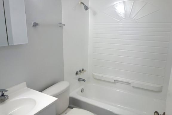 A white bathroom with a sink, toilet and bathtub.