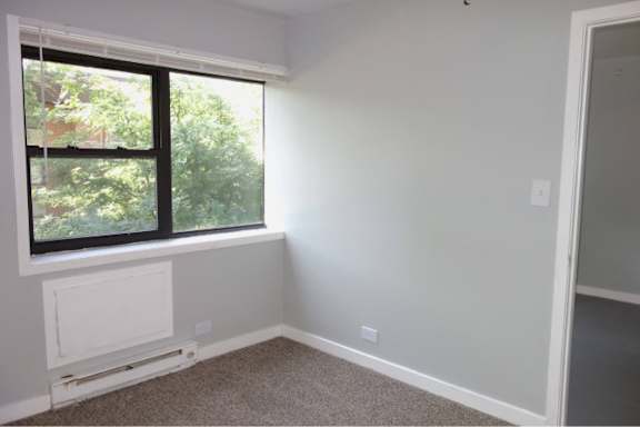 A room with a window and a white door.