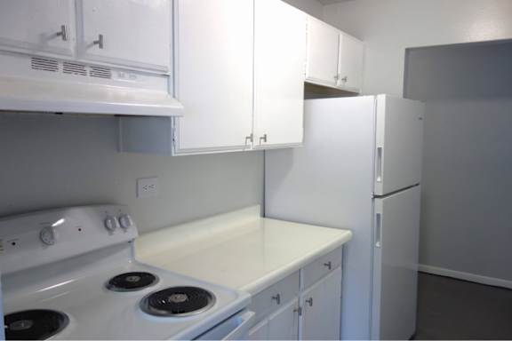 A white stove and oven in a kitchen with white cabinets.