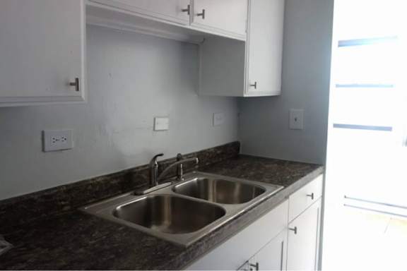 A kitchen with a sink and a counter.