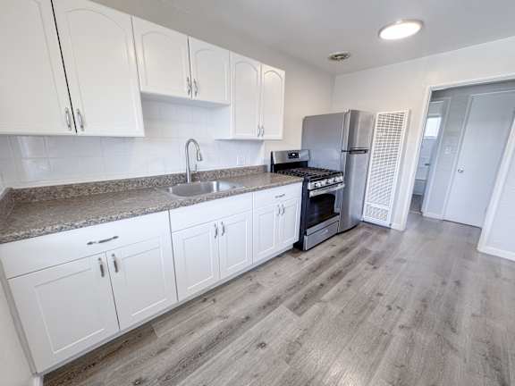 Willow Manor 1bed 1 bath floorplan - kitchen with plank flooring, upgraded white cabinets &amp; stainless steel fridge and oven/stove.
