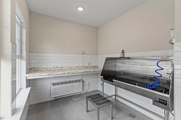 A clean, empty kitchen with a stainless steel oven and a small table.