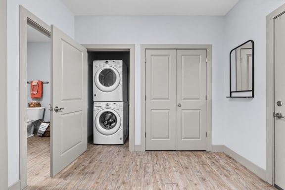 a white washer and dryer in a white room with doors