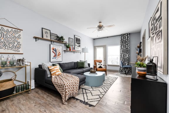 a living room with a couch and a coffee table and a ceiling fan at the vue apartments in indianapolis