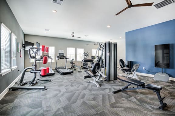 fitness room with weight machines and a treadmill