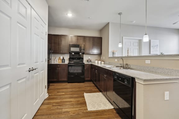 an open kitchen with a large island and black appliances at The Loft apartments in Slidell, LA