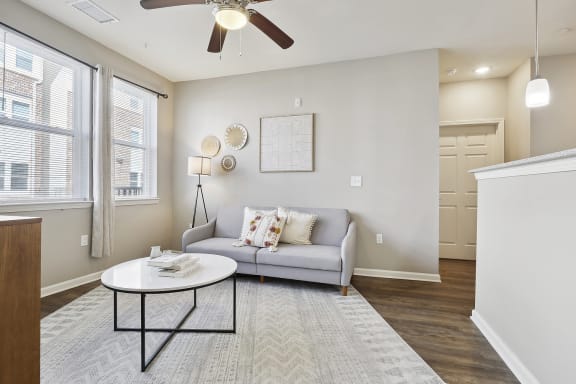 living room with a couch, coffee table, and windows at the Lofts apartments in slidell