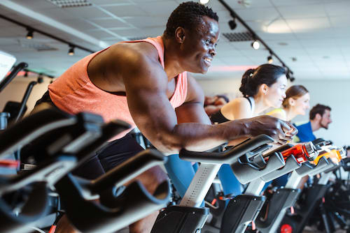 Several people riding on stationary bikes