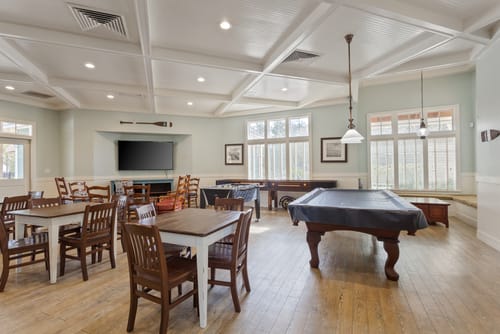Large room with small tables and a pool table